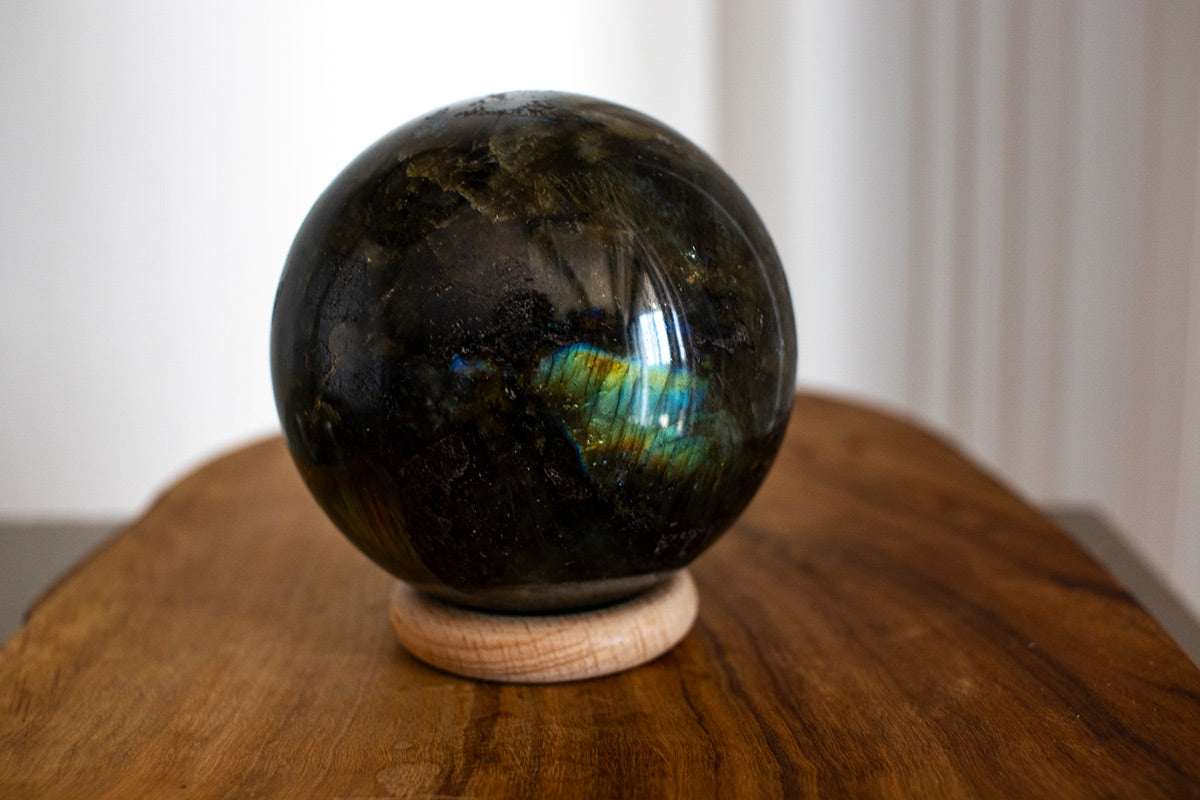 Healing crystal ball made of labradorite showing vibrant flashes under light