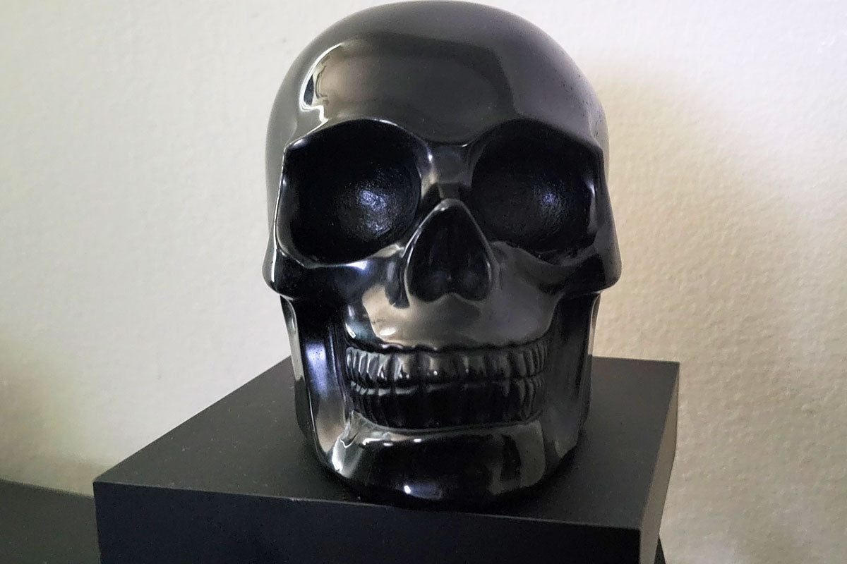Polished obsidian skull sculpture with deep black shine