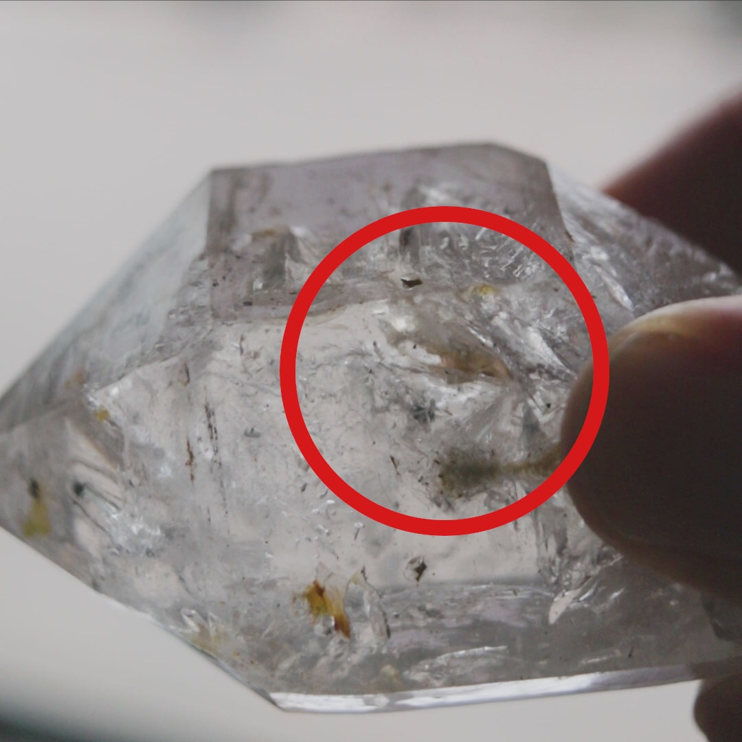 Close-up of natural enhydro quartz point highlighting moving water pocket