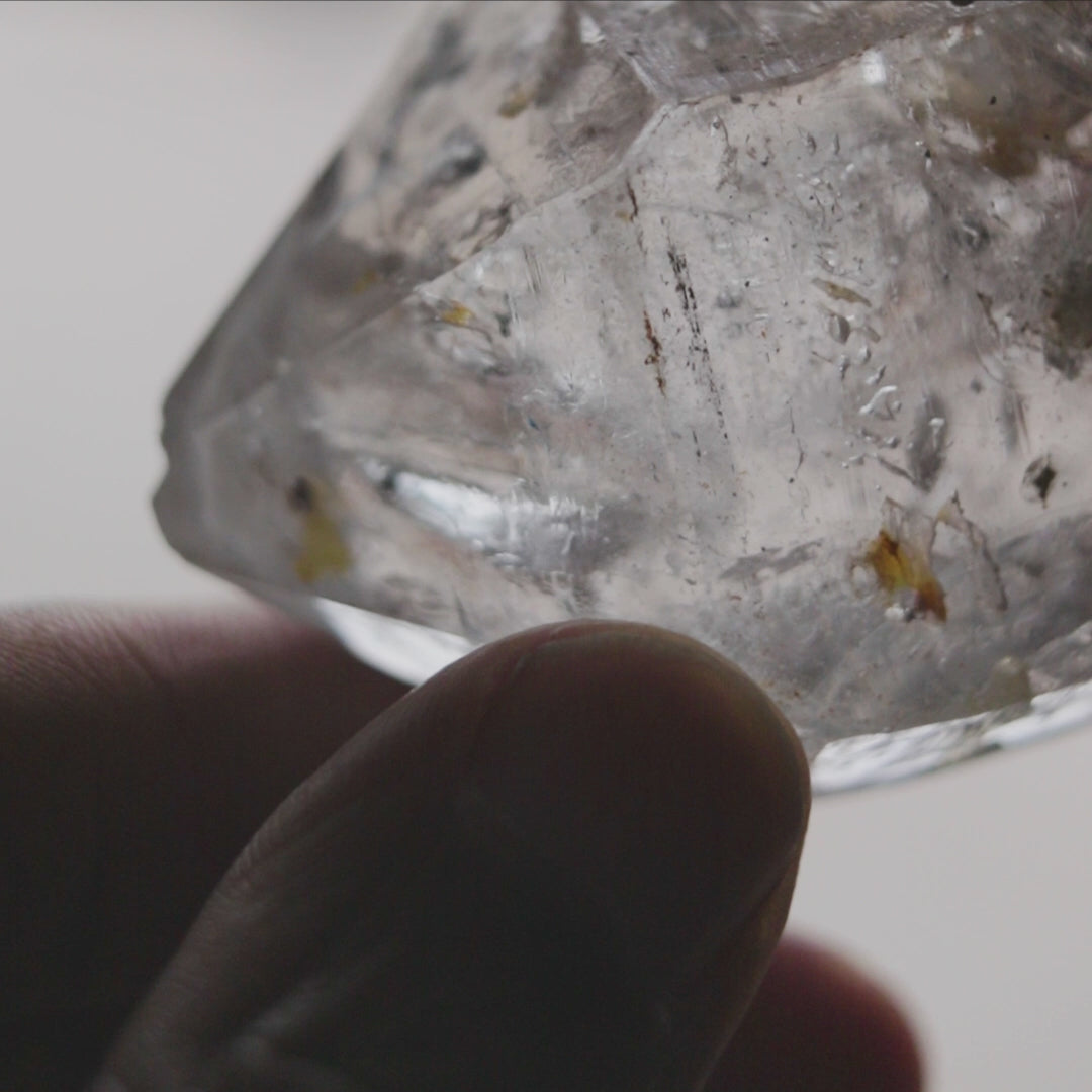 Close-up of natural enhydro quartz point highlighting moving water pocket